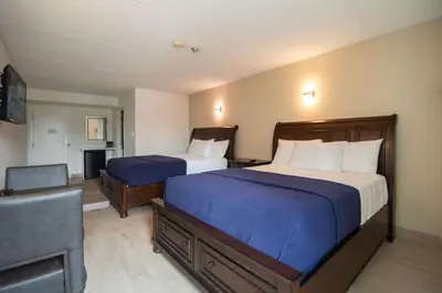a hotel room with two beds and a flat screen tv at Diplomat Inn in Niagara Falls