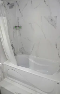 a white bath tub in a bathroom with marble walls at Diplomat Inn in Niagara Falls