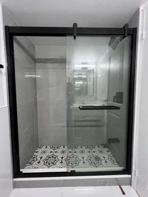 a glass shower in a bathroom with a sink at Diplomat Inn in Niagara Falls