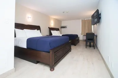 a hotel room with two beds and a television at Diplomat Inn in Niagara Falls
