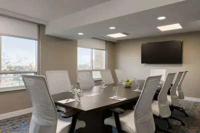a conference room with a long table and white chairs at Embassy Suites By Hilton Toronto Airport in Toronto