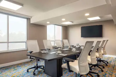 a conference room with a table and chairs and a flat screen tv at Embassy Suites By Hilton Toronto Airport in Toronto