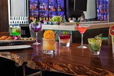 a bar with several cocktails on a wooden table at Embassy Suites By Hilton Toronto Airport in Toronto
