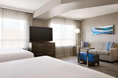 a hotel room with two beds and a flat screen tv at Embassy Suites By Hilton Toronto Airport in Toronto