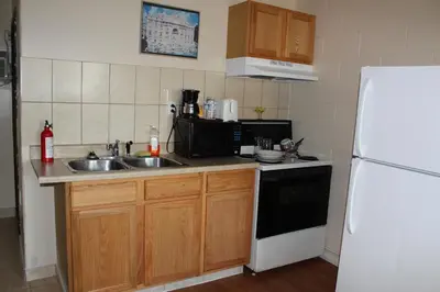 a kitchen with a sink and a white refrigerator at Ritz Inn Niagara in Niagara Falls