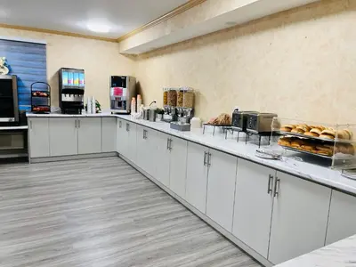 a kitchen with white cabinets and a counter with pastries at The Glengate Hotel & Suites in Niagara Falls