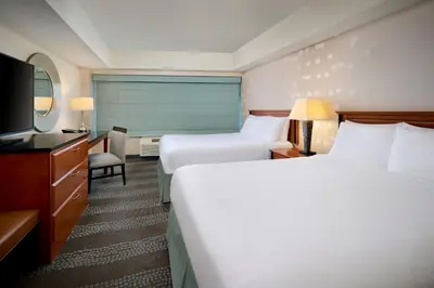 a hotel room with two beds and a television at Niagara Fallsview Hotel in Niagara Falls