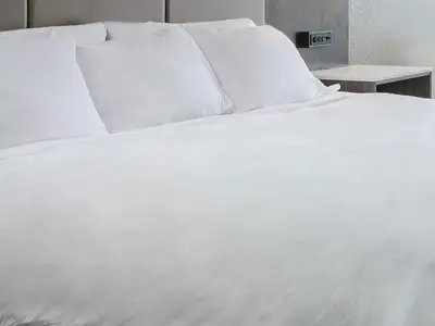 a white bed with white sheets and pillows at Niagara Fallsview Hotel in Niagara Falls