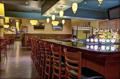 a bar in a restaurant with a lot of chairs at Niagara Fallsview Hotel in Niagara Falls