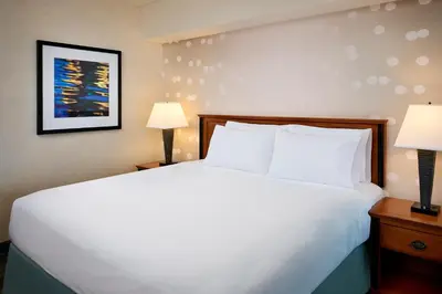 a bedroom with a large white bed with two lamps at Niagara Fallsview Hotel in Niagara Falls