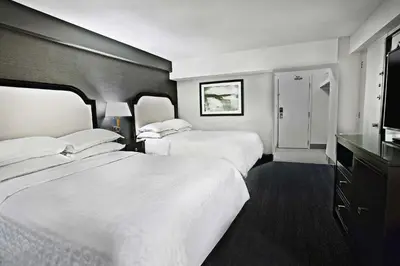 a hotel room with two beds and a television at Sheraton Fallsview Hotel in Niagara Falls