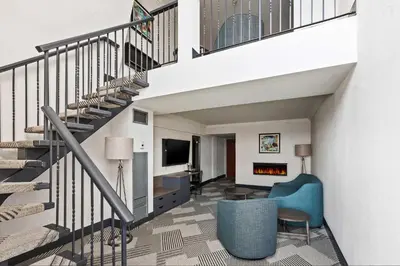 a living room with a staircase and a blue chair at Sheraton Fallsview Hotel in Niagara Falls