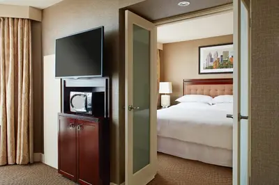 a hotel room with a bed and a flat screen tv at Sheraton Parkway Toronto North Hotel & Suites in Richmond Hill