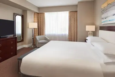 a hotel room with a large white bed and a television at Sheraton Parkway Toronto North Hotel & Suites in Richmond Hill