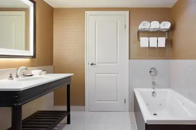 a bathroom with a sink and a tub and a toilet at Sheraton Parkway Toronto North Hotel & Suites in Richmond Hill