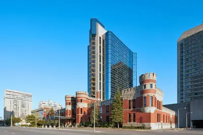 a tall red brick building in a city with tall buildings at Delta Hotels by Marriott London Armouries in London