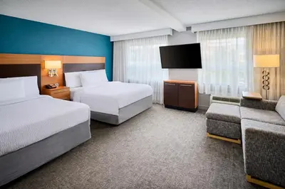 a hotel room with two beds and a couch at TownePlace Suites by Marriott Mississauga-Airport Corporate Centre in Mississauga