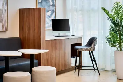 a waiting room with two stools and a tv on a fireplace at TownePlace Suites by Marriott Mississauga-Airport Corporate Centre in Mississauga