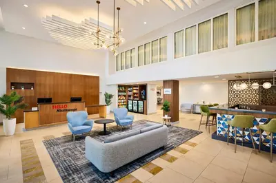 a lobby with a couch and chairs and a bar at TownePlace Suites by Marriott Mississauga-Airport Corporate Centre in Mississauga