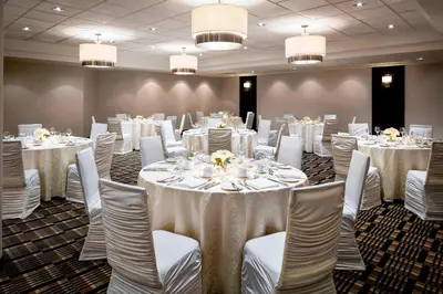 a room filled with tables and chairs with white table cloth at Four Points by Sheraton Mississauga Meadowvale in Mississauga
