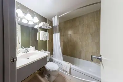 a bathroom with a sink and a toilet and a tub at Days Inn by Wyndham Fallsview in Niagara Falls