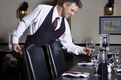 a man standing at a table with a glass of wine at The Oakes Hotel Overlooking the Falls in Niagara Falls