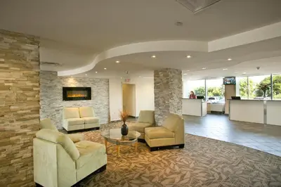 a lobby with two chairs and a table in a building at The Oakes Hotel Overlooking the Falls in Niagara Falls