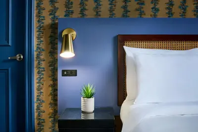 a blue bedroom with a bed and a table with a plant at Hotel Victoria in Toronto