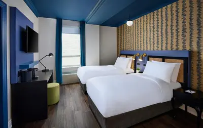a hotel room with two beds and a television at Hotel Victoria in Toronto