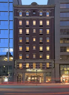 a tall building with many windows on the side of it at Hotel Victoria in Toronto