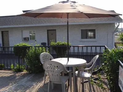 a table and chairs with an umbrella in front of a house at Falcon Inn in Niagara Falls