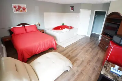 a bedroom with a bed and a bath tub at Falcon Inn in Niagara Falls