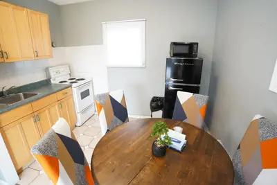 a kitchen with a wooden table and chairs in a kitchen at Falcon Inn in Niagara Falls
