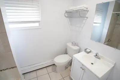 a white bathroom with a toilet and a sink at Falcon Inn in Niagara Falls