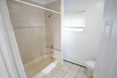 a white bathroom with a tub and a toilet at Falcon Inn in Niagara Falls