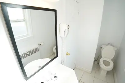 a mirror in a bathroom with a toilet and a sink at Falcon Inn in Niagara Falls