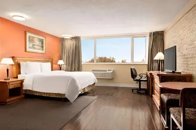 a hotel room with a bed and a large window at Travelodge by Wyndham Richmond Hill in Richmond Hill
