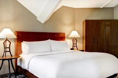 a bedroom with a large white bed with two lamps at Four Points by Sheraton St. Catharines Niagara Suites in Thorold