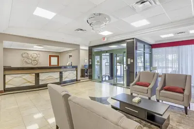 a living room with two chairs and a table at Best Western Plus Travel Hotel Toronto Airport in Toronto