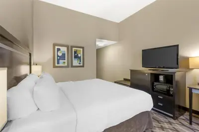 a hotel room with a bed and a flat screen tv at Best Western Plus Travel Hotel Toronto Airport in Toronto