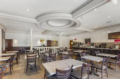 a restaurant with tables and chairs and a bar at Best Western Plus Travel Hotel Toronto Airport in Toronto