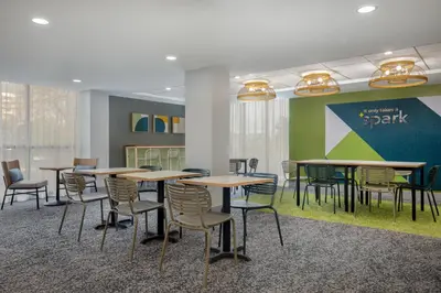 a group of tables and chairs in a room at Spark by Hilton Toronto Airport in Toronto