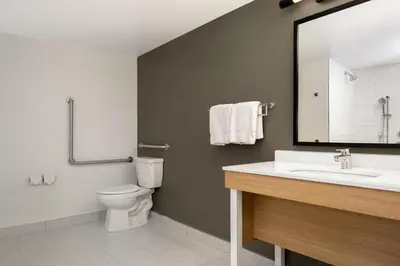 a bathroom with a sink and a toilet and a mirror at Spark by Hilton Toronto Airport in Toronto