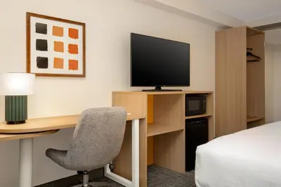 a hotel room with a desk with a television and a bed at Spark by Hilton Toronto Airport in Toronto