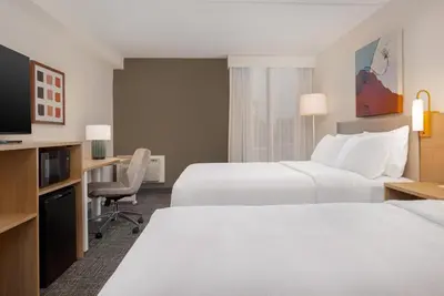 a hotel room with two beds and a desk at Spark by Hilton Toronto Airport in Toronto