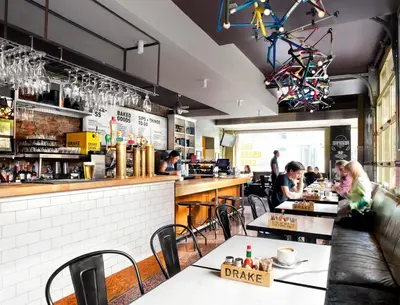 a restaurant with people sitting at tables and a bar at The Drake Hotel in Toronto