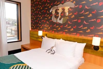 a bedroom with a bed and a wall with birds at The Drake Hotel in Toronto