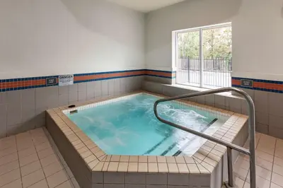 a jacuzzi tub in a bathroom with a window at Best Western Plus Burlington Inn & Suites in Burlington