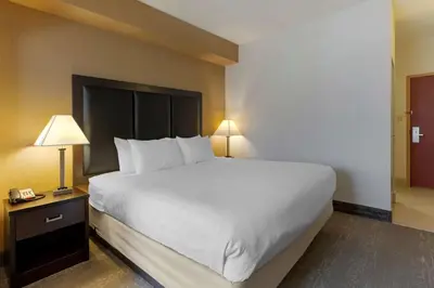 a large bed in a hotel room with a telephone at Best Western Plus Burlington Inn & Suites in Burlington