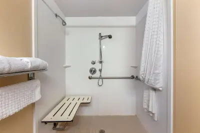 a bathroom with a bench next to a shower at Best Western Plus Burlington Inn & Suites in Burlington